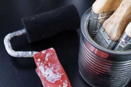 Brushes for painting with paint and cans on a workshop table. Painting accessories prepared for painting. Dark background.の写真素材