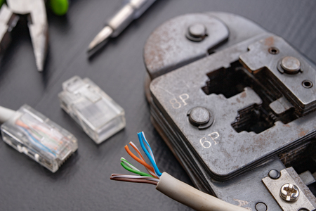 Work in a workshop on connections used in electronics. Computer cables and connectors rj44. Dark background.の写真素材