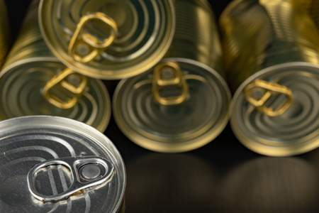 Damaged metal can with vegetables on a wooden table. Canned vegetables in a can. Dark background.の写真素材