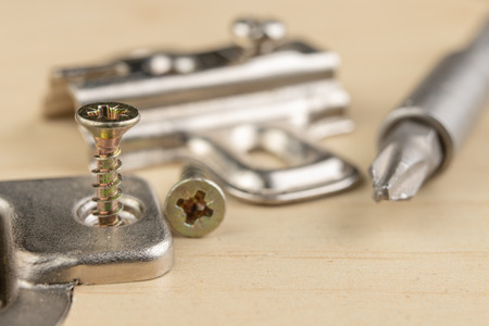 Milling the hole for the can hinge. Joinery works when assembling chipboard furniture. light background.の写真素材