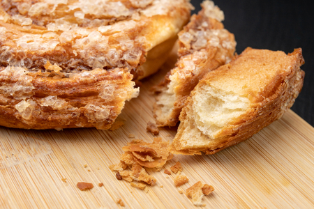 Tasty cookie broken in half. Fresh bread on a kitchen board. Light background.の写真素材