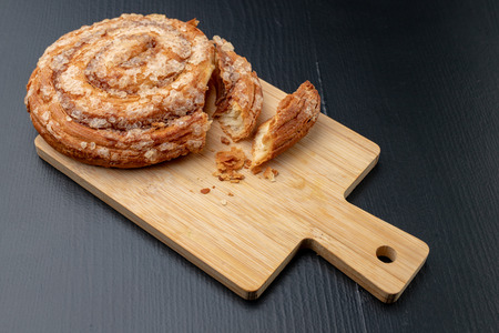 Tasty cookie broken in half. Fresh bread on a kitchen board. Light background.