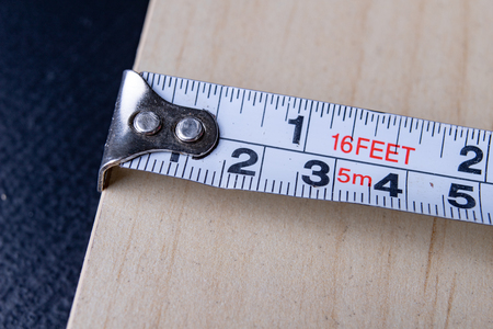 Steel measure and pencil used for measuring in carpentry. Diy accessories on the workshop table....