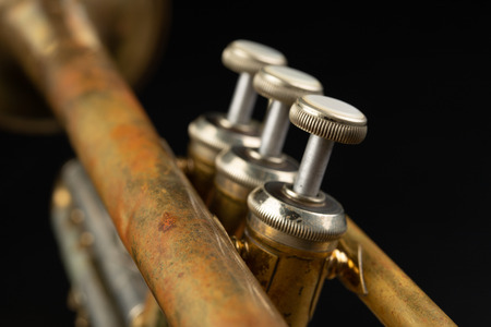 Old coated patina trumpet on a dark table. An inedible musical instrument. Dark background.の写真素材