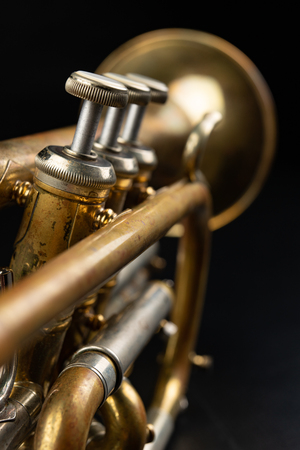 Old coated patina trumpet on a dark table. An inedible musical instrument. Dark background.の写真素材