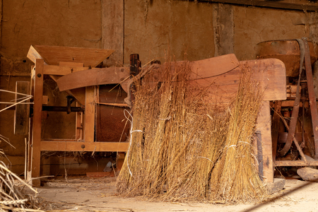A barn in an old farm. Old machines helpful in agriculture. Season of the spring.の写真素材