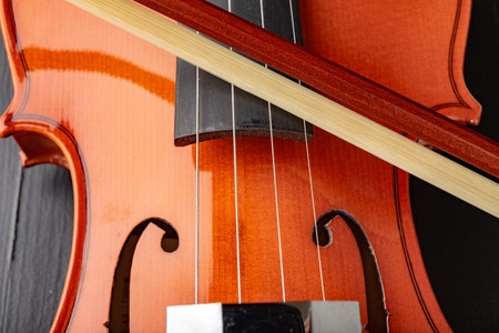 Beautiful new shiny violin on a dark table. Musical string instrument prepared for work. Dark...