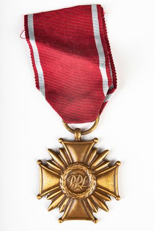 Czluchow, pomorskie / Poland - April, 8, 2019: An old  badge for distinguished activists. A cross for  activists in Poland. Light background.のeditorial素材