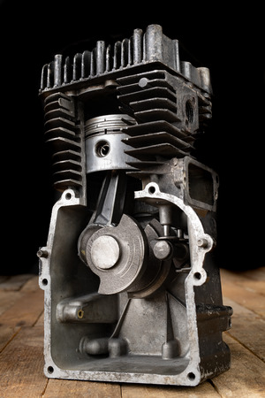 A four-stroke gasoline engine in section. The interior of a single-cylinder internal combustion engine. Dark background.の写真素材