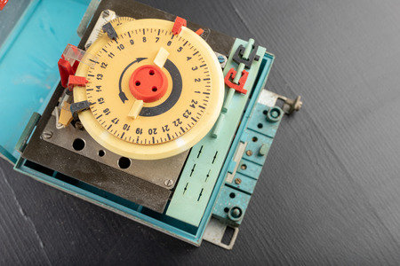 Electrical device for industrial time measurement. An old counter for switching electrical devices. Dark background.の写真素材