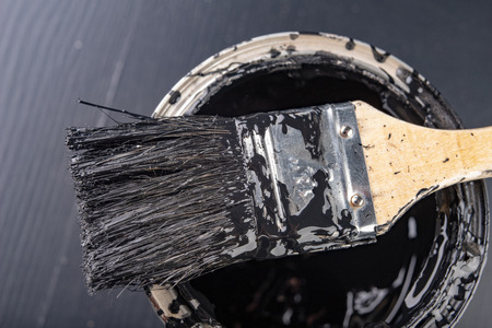 Old paint brush and metal can with paint. Accessories for painting oil paint dirty with black paint. Dark background.の写真素材