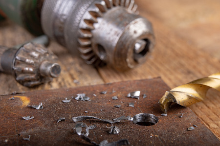 Drilling with a metal drill. Small locksmith work in the home workshop. Dark background.の写真素材