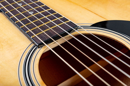 Classical guitar on a dark wooden table. Musical instrument stringed. Black background.