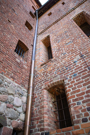 Old copper drain gutter in a brick building. Installation that drains water from the roof. Season springの写真素材