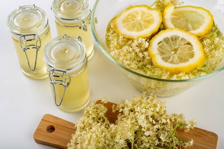 Juice from the flowers of a black elderberry on a white table. Therapeutic cold syrup prepared for storage for the winter. Light background.の写真素材