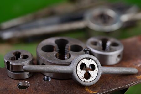 Manual thread cutting in metal. Locksmith accessories for small work in the home workshop. Dark...