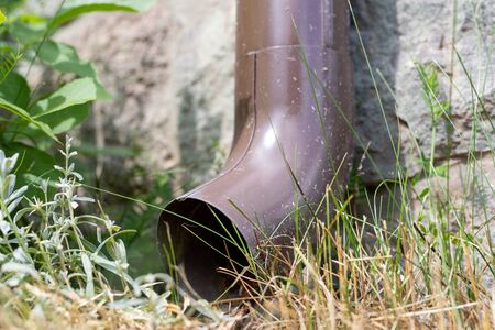 An old gutter in a detached house. Rainwater drainage from the roof. Season of the summer.