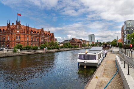 Bydgoszcz, kujawskopomorskie / Poland - June 27, 2019: Beautiful historic buildings on the Brda River. Old tenements and modern buildings on the banks of the river in Central Europe. Season of the summer.のeditorial素材