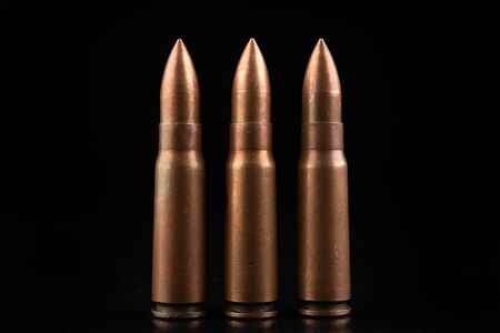 Ammunition of a high-speed rifle. Cartridges for a military rifle. Dark background.