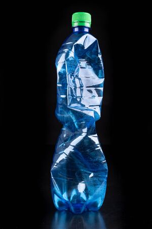 Plastic bottle on a dark table. Plastic container for drinking water. Black background.の写真素材