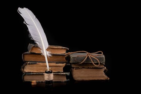 Feathers of birds for writing and calligraphy on old paper. A place for an old writer. Dark background.の写真素材