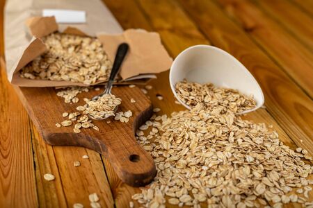 Tasty oatmeal on a wooden kitchen table. Healthy food used for slimming diets for obese people. Autumn background.の写真素材