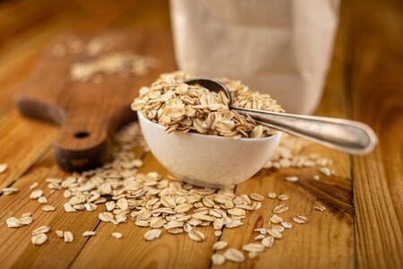 Tasty oatmeal on a wooden kitchen table. Healthy food used for slimming diets for obese people. Autumn background.の写真素材