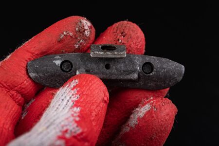 Lead weights on the rim on the red glove. Accessories for the vulcanizer in the workshop. Dark background.の写真素材