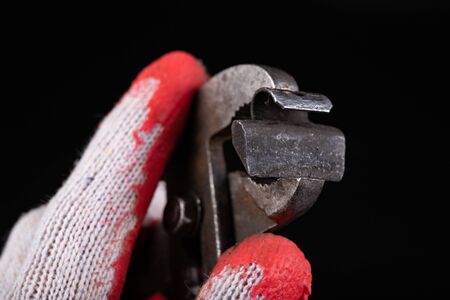 Lead weights on the rim of the pliers. Accessories for the vulcanizer in the workshop. Dark background.の写真素材