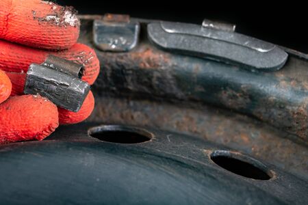 Lead weights on the rim. Accessories for the vulcanizer in the workshop. Dark background.