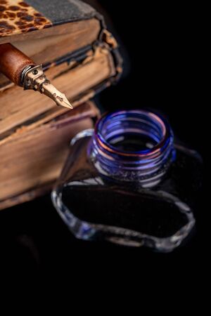 An old nib for writing in ink on a dark table. Antique calligraphy accessories. Black background.の写真素材