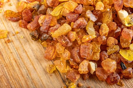 Small raw amber on a wooden table. A precious find from the coast of Central Europe. Light...