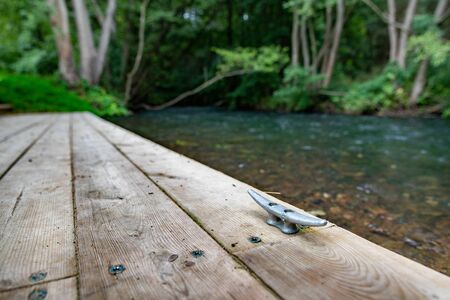 A wooden jetty at a rushing river. marina for canoeists in Central Europe. Summer season.の写真素材