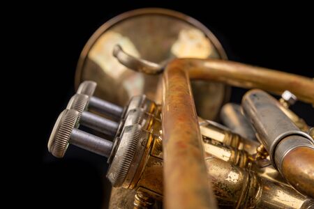 Trumpet covered with patina on a dark table. Neglected musical instrument. Black background.の写真素材