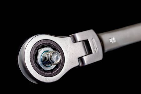 Nickel-plated nuts and wrenches on a workshop table. Tools in a mechanical workshop. Dark...