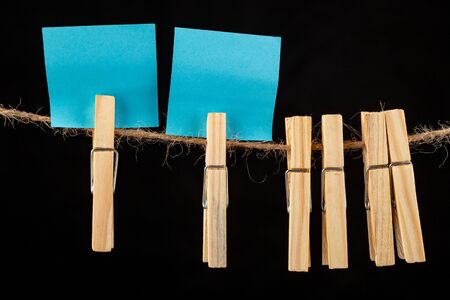 Wooden buckles hung on a clothesline and colored cards. Place on the cards for text messages. Dark background.の写真素材
