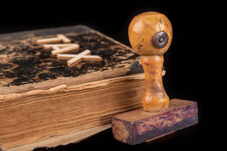 Inscription tax on an old book and stamp. Office accessories on a dark table. Black background.の写真素材