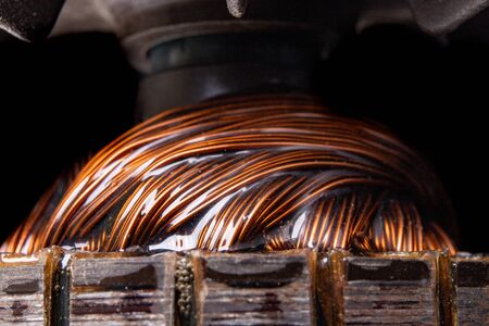 Copper electric motor winding. Electric mechanism rotor. Dark background.