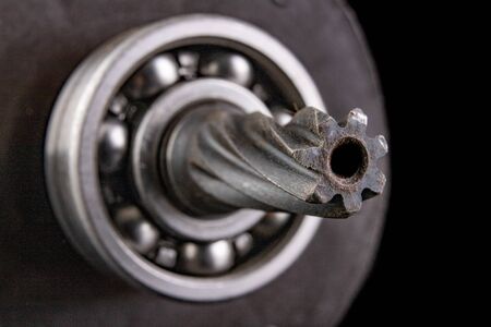 Milled spindle and bearing on the rotor shaft of the electric motor. Mechanical parts on a dark table. Black background.の写真素材