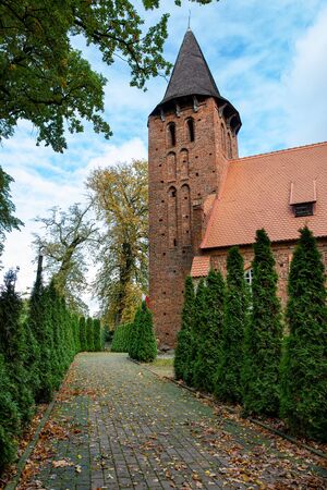 A small church built of red brick. Christian Temple in Central Europe. Autumn season.の写真素材