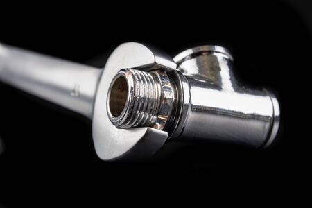 New nickel-plated wrench and hydraulic connector on a workbench. Hydraulic accessories. Dark...