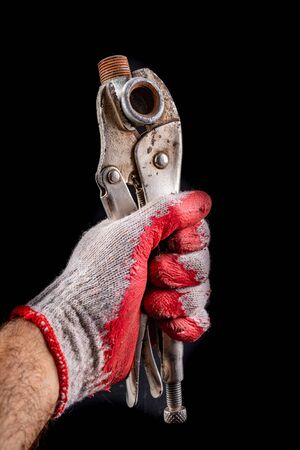 Old adjustable wrench and hydraulic coupling in the palm of your hand. Hydraulic accessories. Dark background.の写真素材