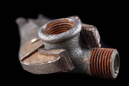 Old adjustable wrench and hydraulic connector on a workbench. Hydraulic accessories. Dark background.の写真素材