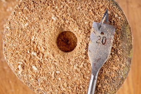 Drilling with a steel drill in wood. Raw wood, machined. Light background.の写真素材