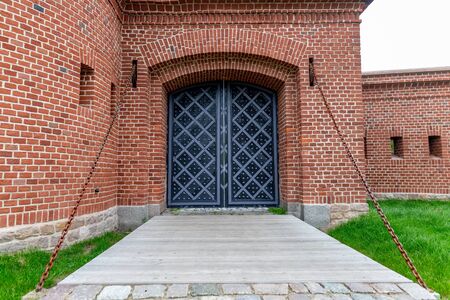 Old historic gate in a brick building. Old building with old doors. Autumn season.の写真素材