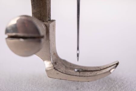 Old sewing machine and white material on a dark table. An antique device for small housework. Dark...