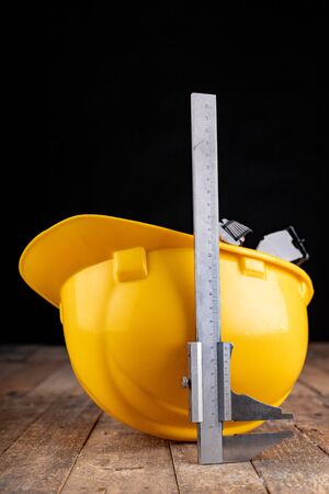 Protective helmet and caliper. Work accessories for production workers and engineers. Dark background.の写真素材
