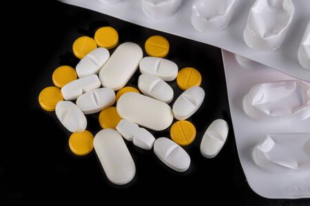 Medical tablets and tablet packaging. Medication on a dark table. Black background.の写真素材