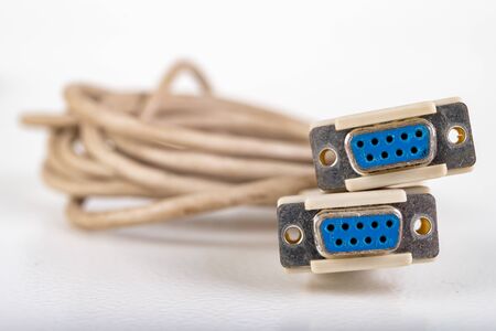 Com-com cable used to connect PCs. Old computer accessories. Light background.