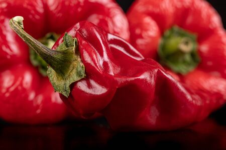 Wrinkled sweet and hot peppers on the table. Dried old vegetables. Dark background.の写真素材